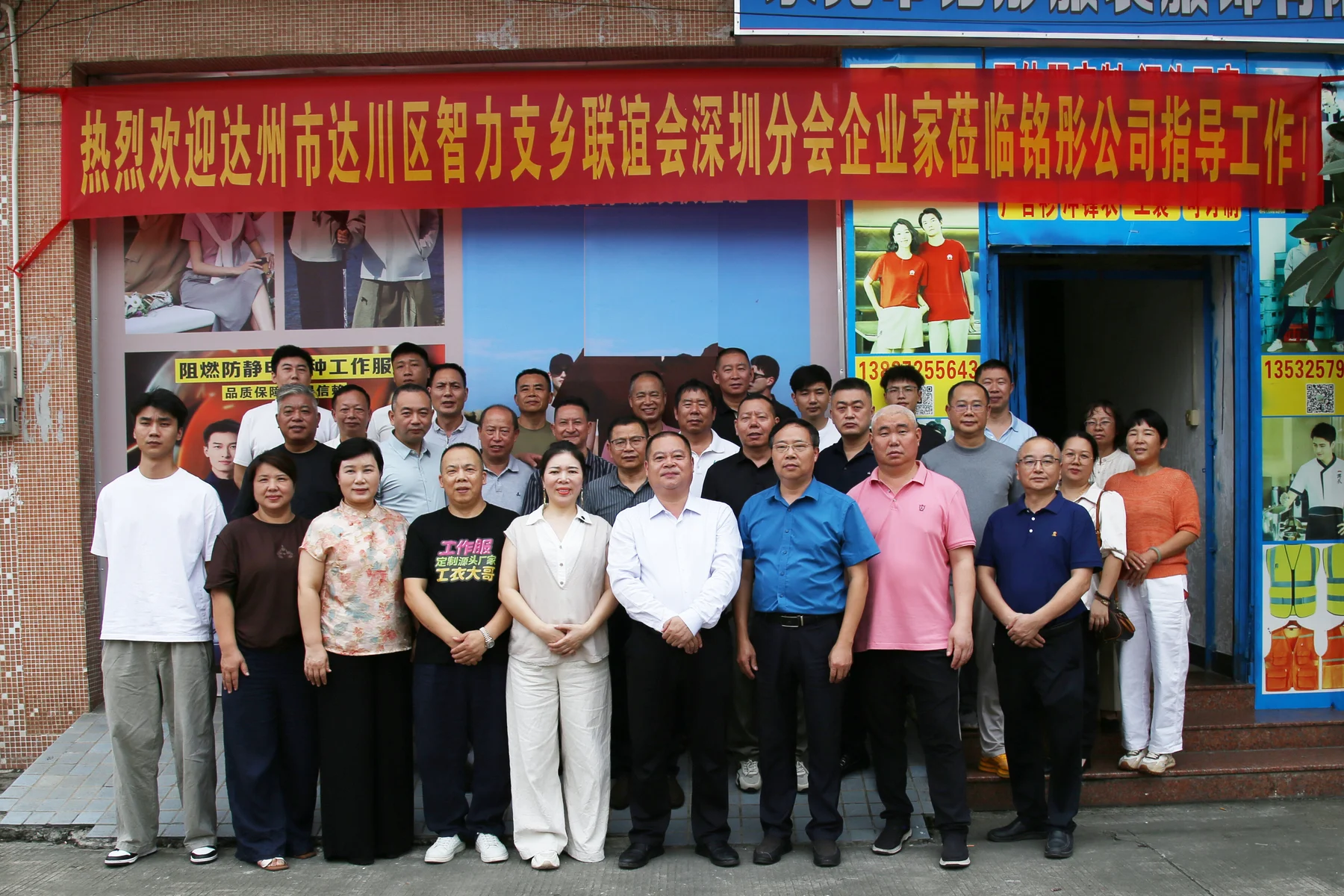 铭彤公司门前合影，背景可见门面与欢迎横幅