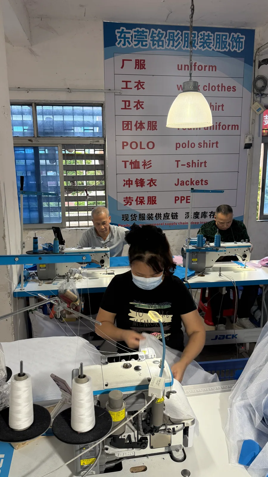 铭彤服装车间内工作人员使用缝纫设备作业