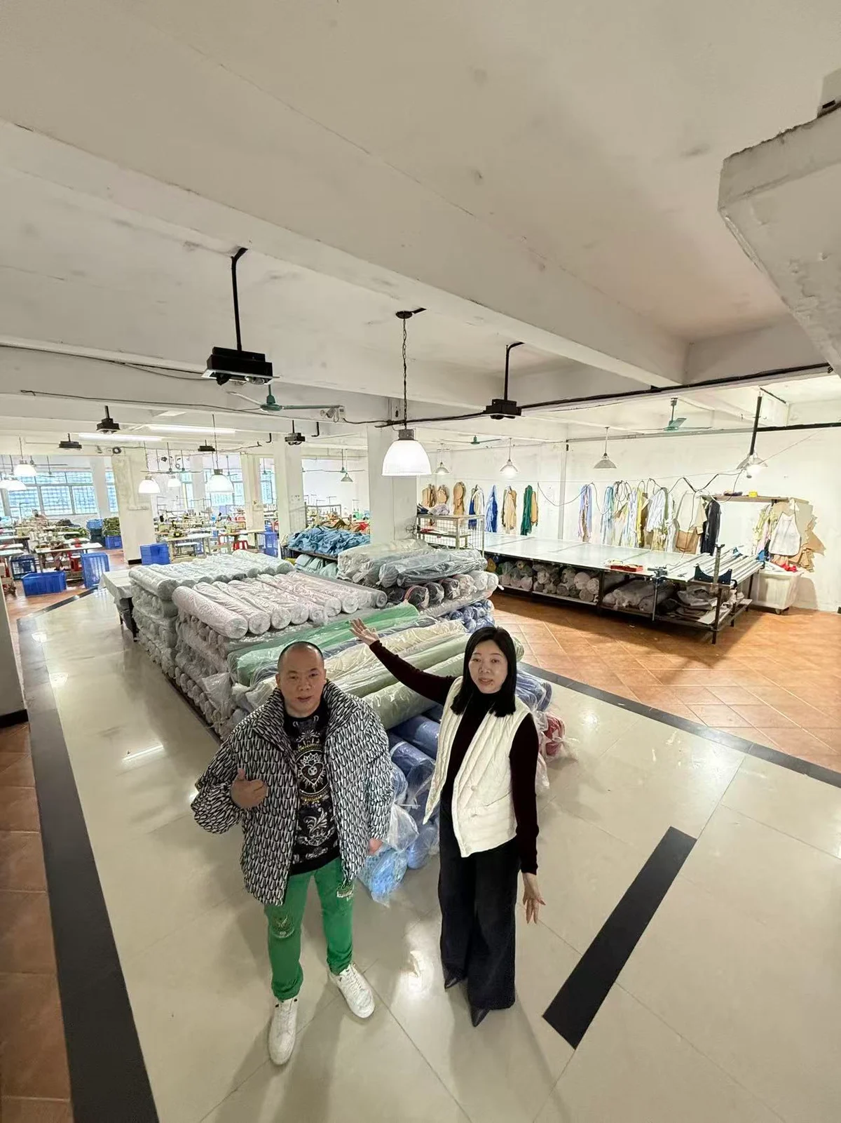 铭彤工厂面料备料区域，成卷面料与车间工作台