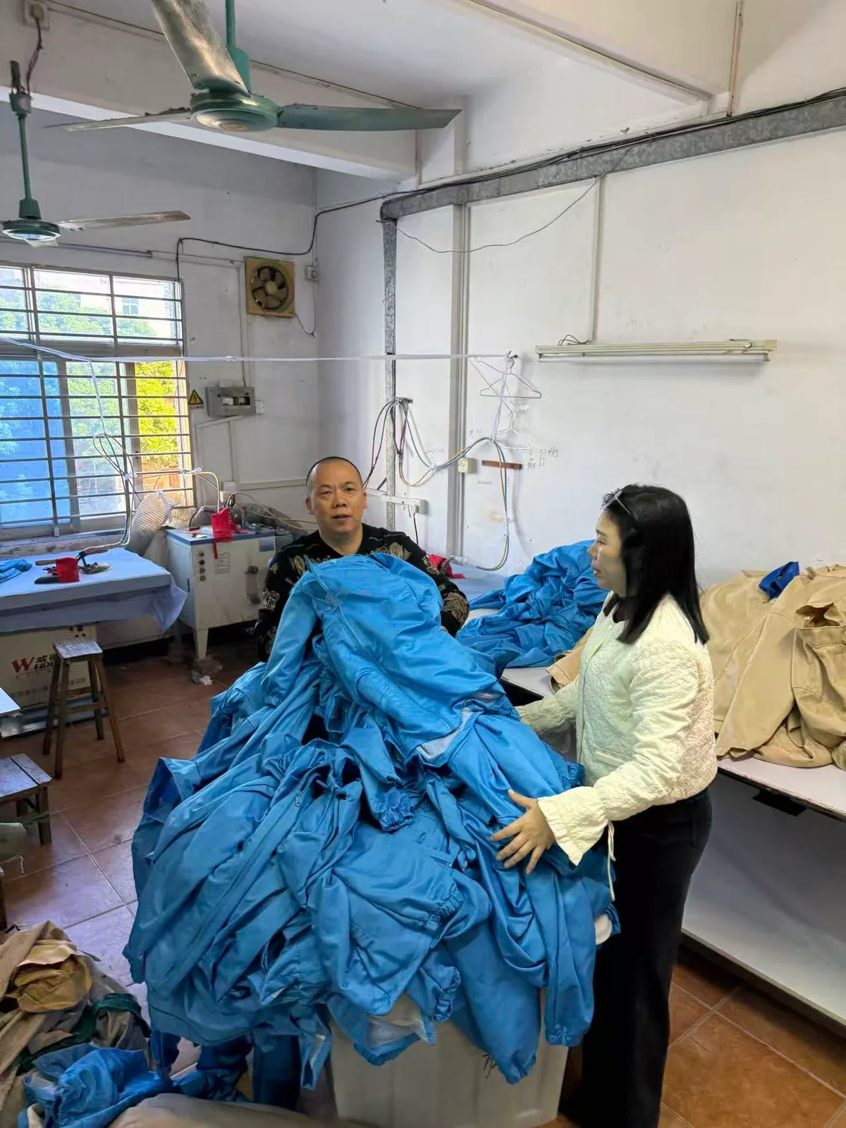 铭彤服装工作台上的蓝色服装整理现场